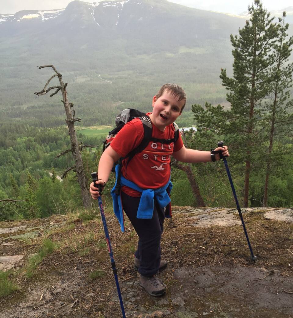 Blid gutt 10år på tur i fjellet med staver.