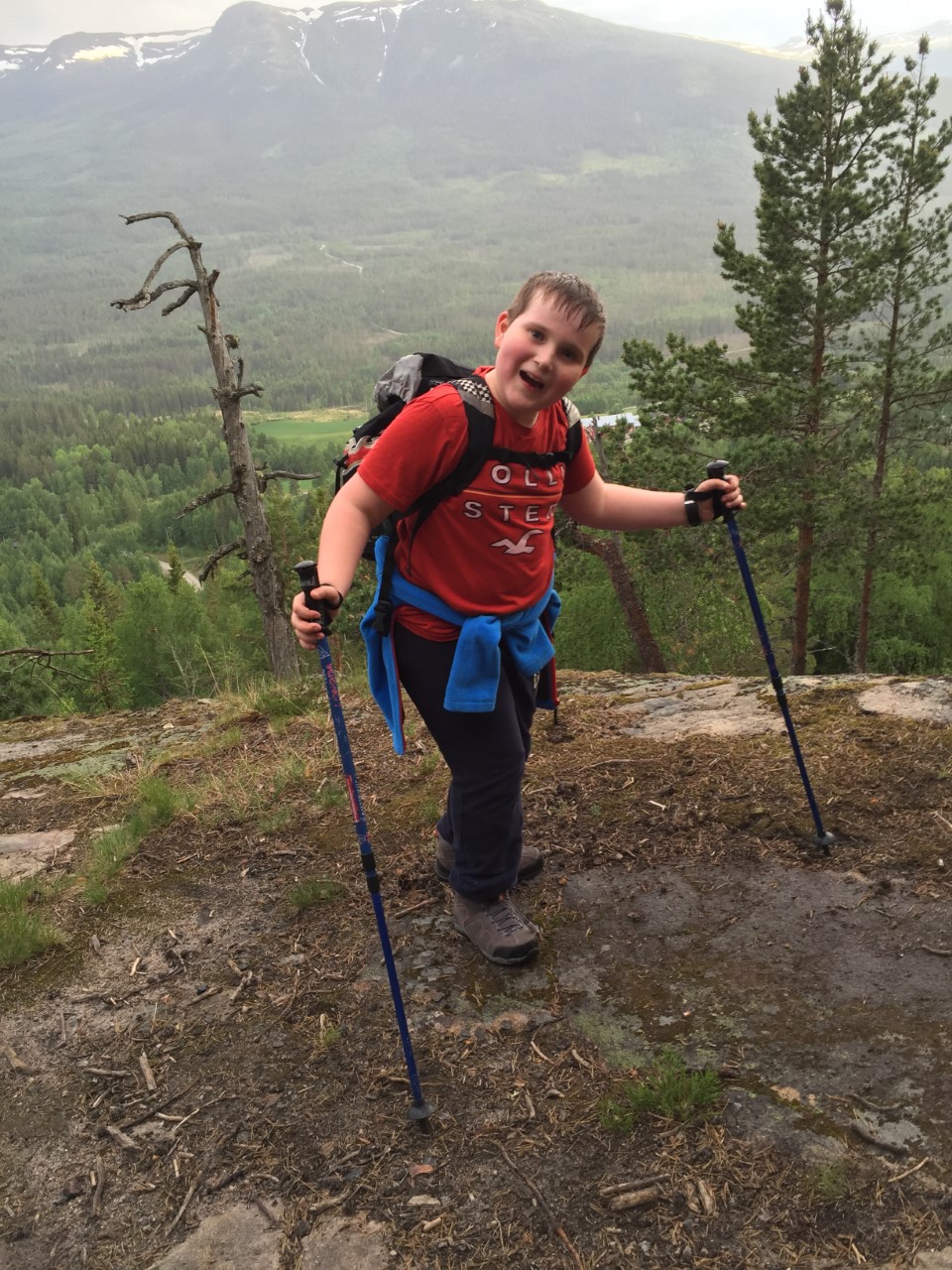 Blid gutt 10år på tur i fjellet med staver.