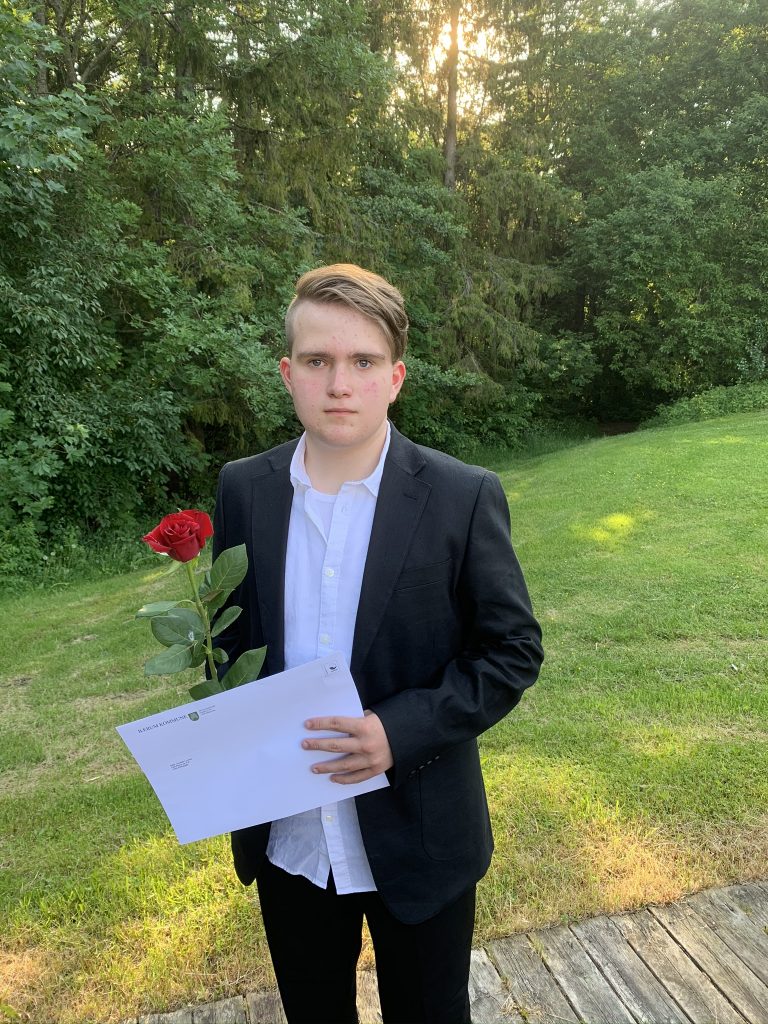 Gutt 16år med dress og rød rose hånden.