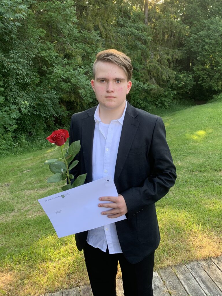 Gutt 16år med dress og rød rose hånden.