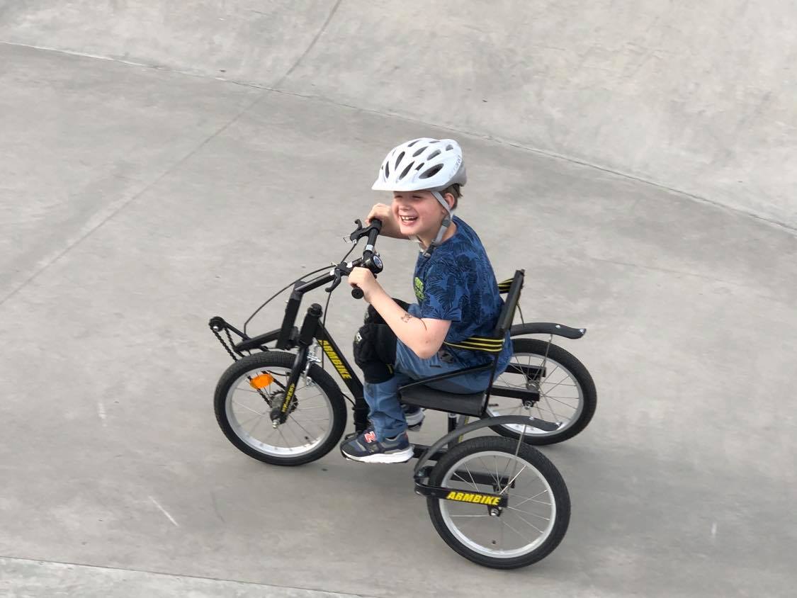 Ung gutt på sykkel hjelpemotor og ett hjul foran og to bak