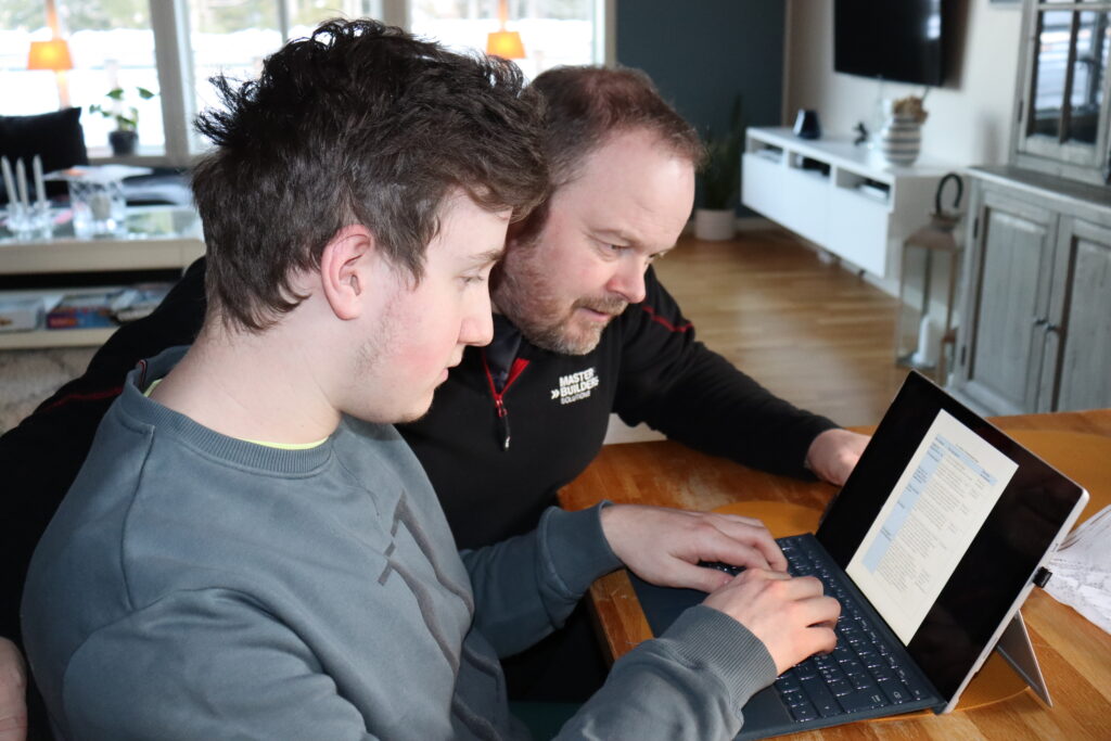 Sander og pappa Tor Andre sitter foran en bærbar PC og ser på Sander sin individuelle plan