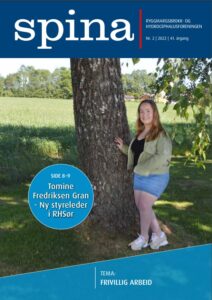 Forsidebilde Spina 2-2022. Ung smilende dame står inntil et stort bjørketre.