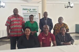 Styret i Papaya Key Fundation (PKF) er en ideell organisasjon i Zambia. Syv personer samlet foran et langbord.