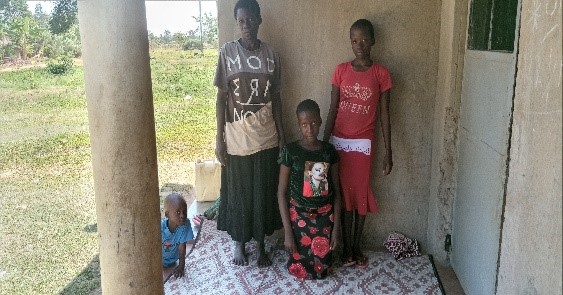Nakato Gladays (mor i Uganda) with her children Mor i Uganda med sine to døtre som har ryggmargsbrokk foran inngangen til sitt hus.